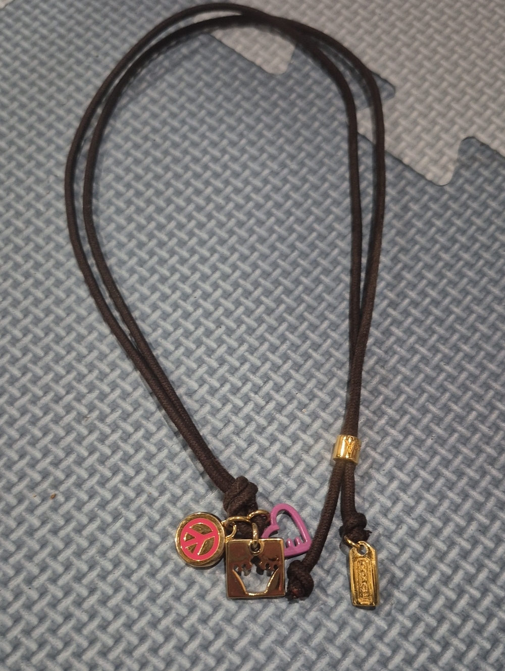Coach Black Cord Necklace with Gold and Pink Charms